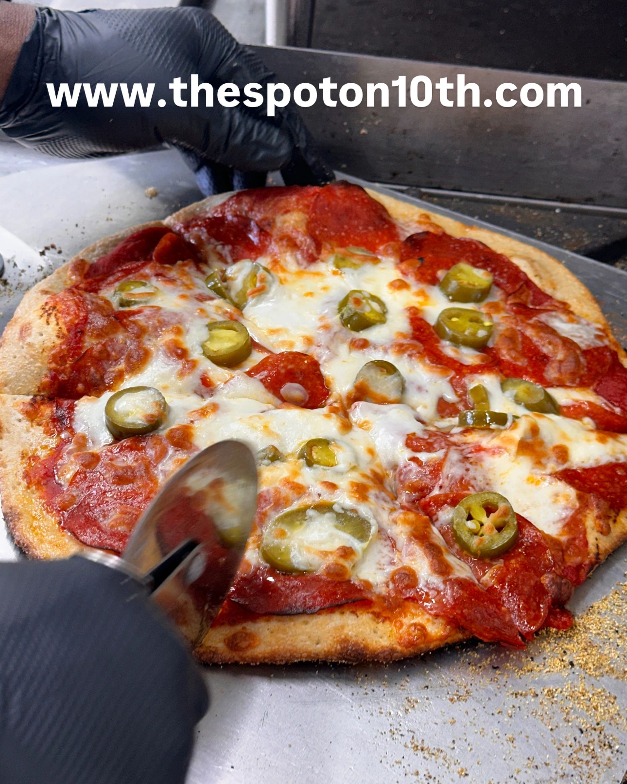 Pepperoni and jalapeño pizza being sliced