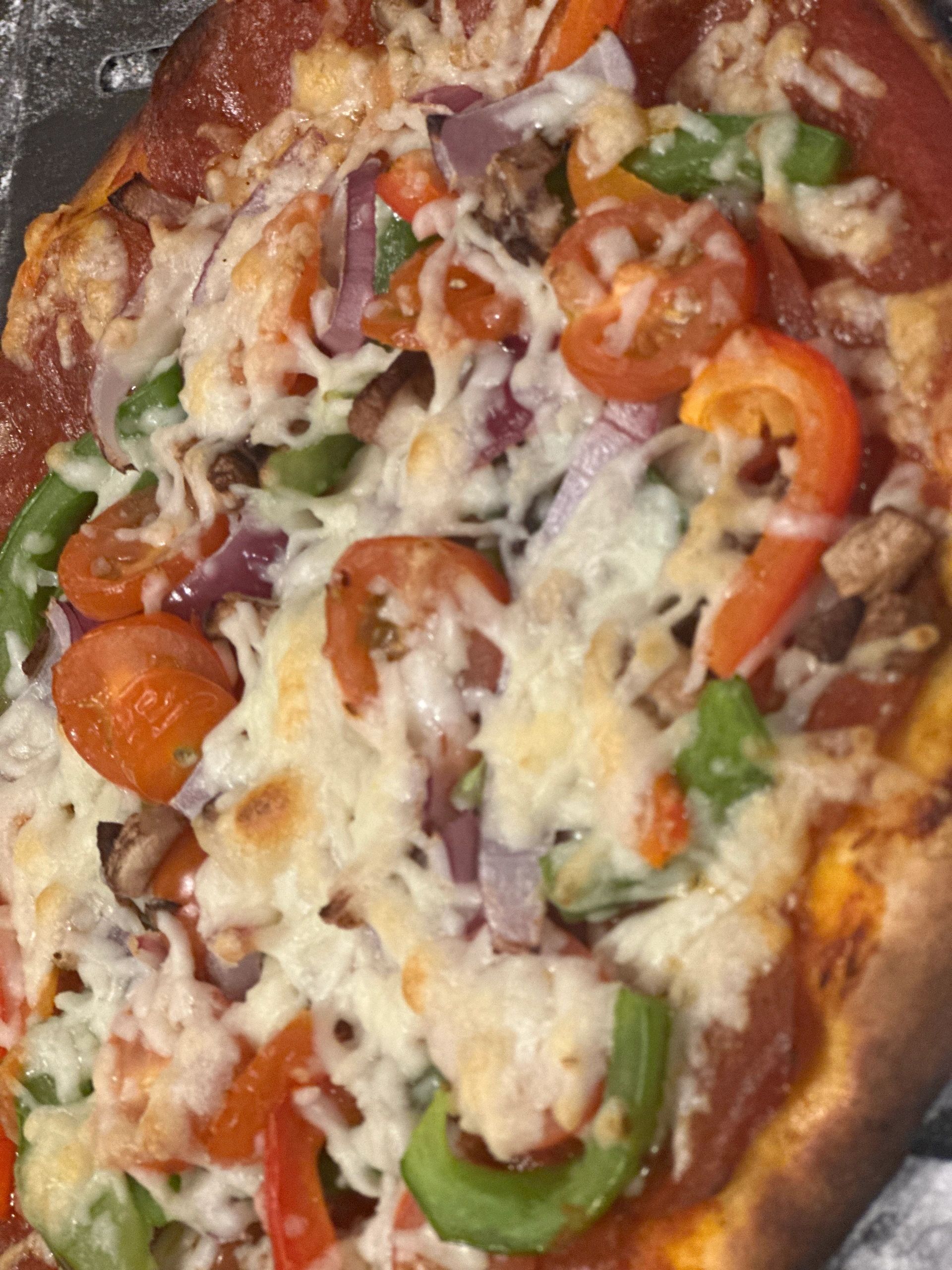Loaded veggie pizza with peppers, tomatoes, onions and mushrooms